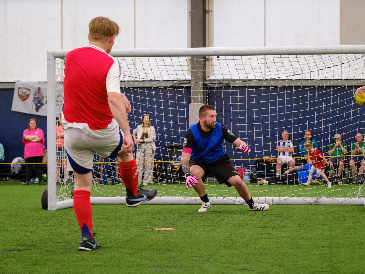 Arsenal player striking his penalty which hits the post.