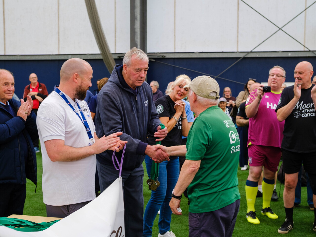 Joe Mayo handing medals to Big C's captain.