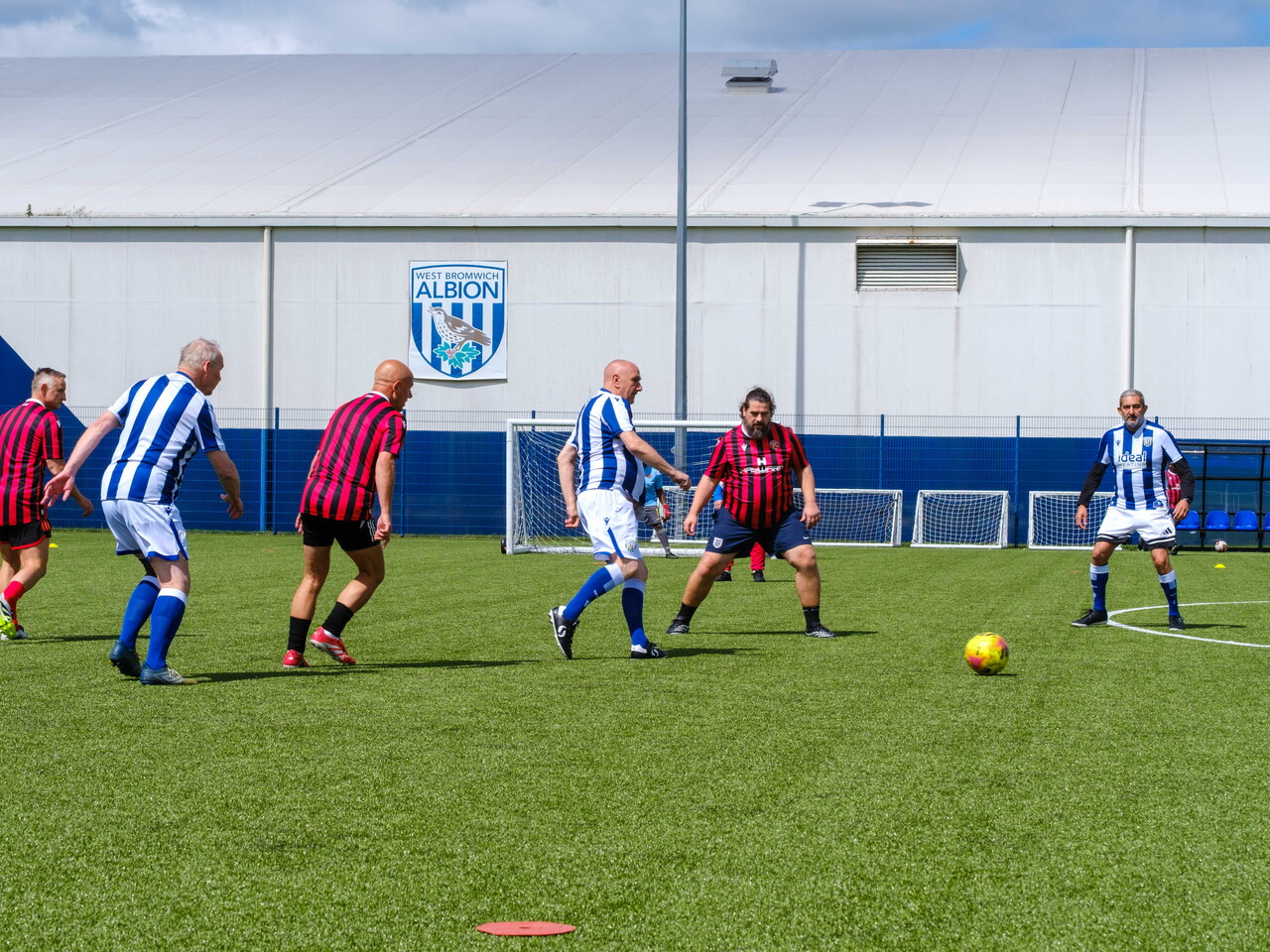Wide shoot of Cancer Kickers and Beat the Block playing on the pitch.