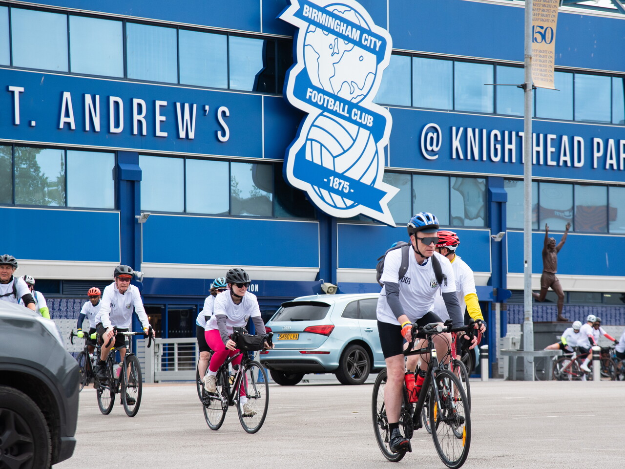  Cyclists pass in front of St Andrew's Stadium during the route.