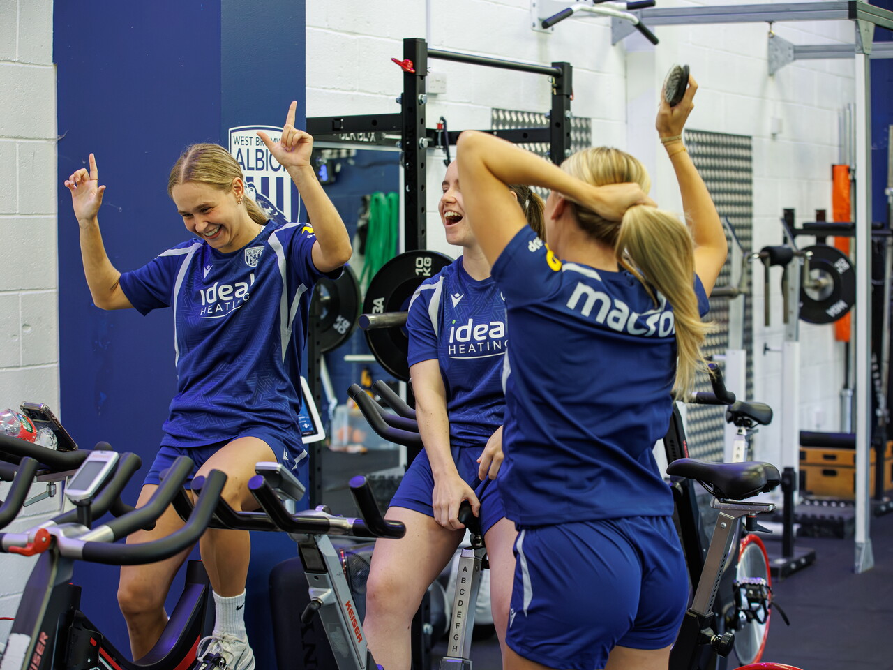 Three Albion Women players laughing and chatting while in the gym
