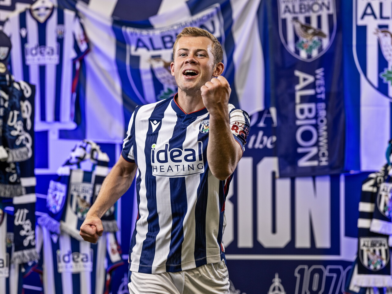 Aune Heggebø in the home kit celebrating towards the camera while stood in front of an Albion back drop with plenty of WBA branding