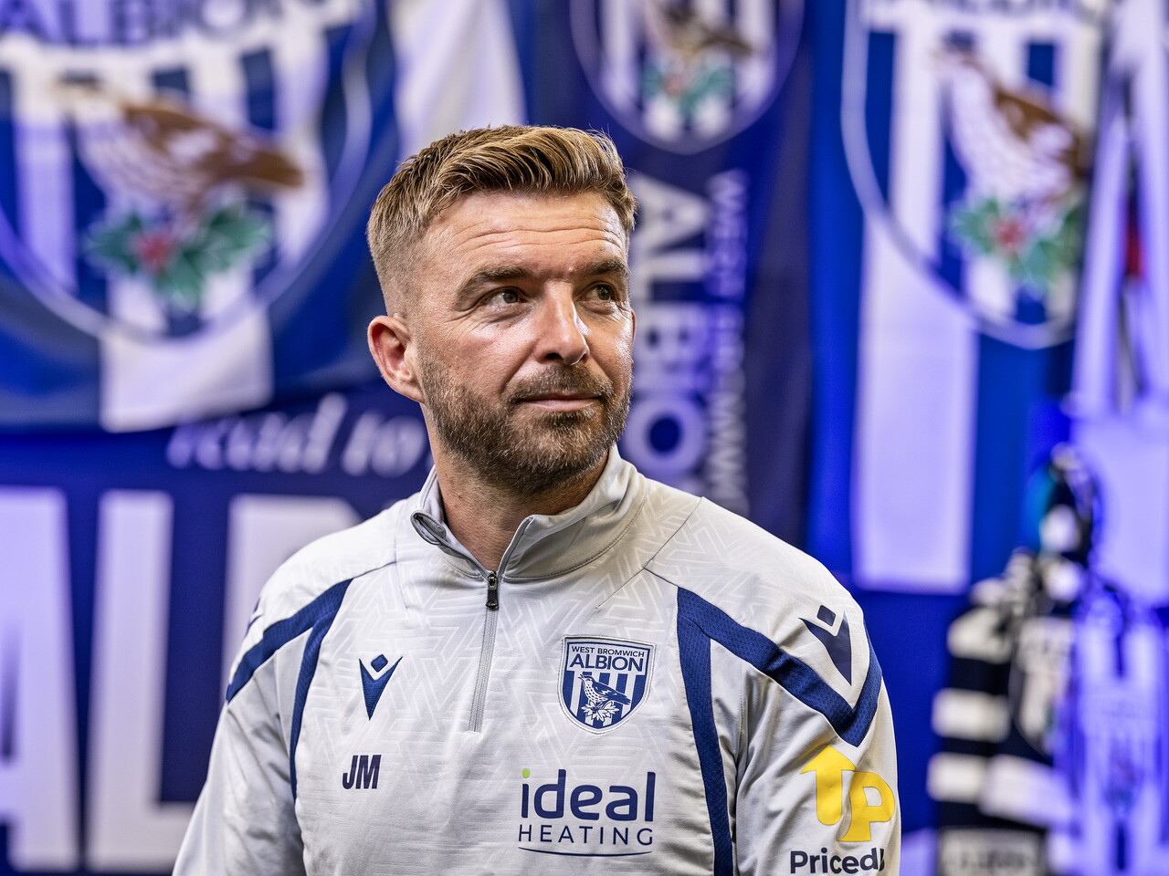 James Morrison looking away from camera while sat in front of an Albion back drop with plenty of WBA branding