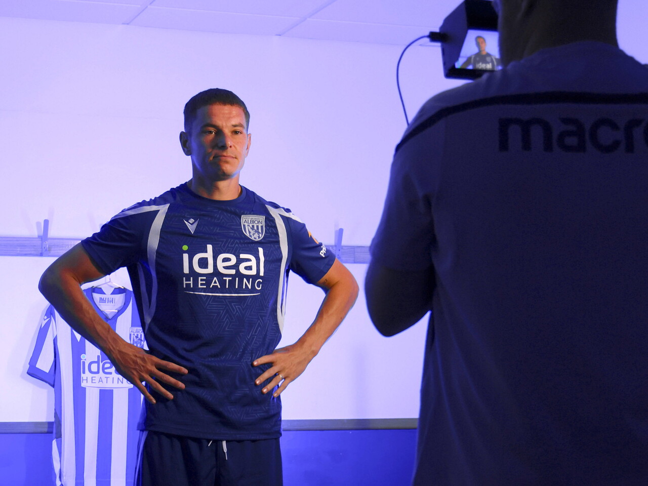 Conor Townsend looking at a video camera while stood in a changing room
