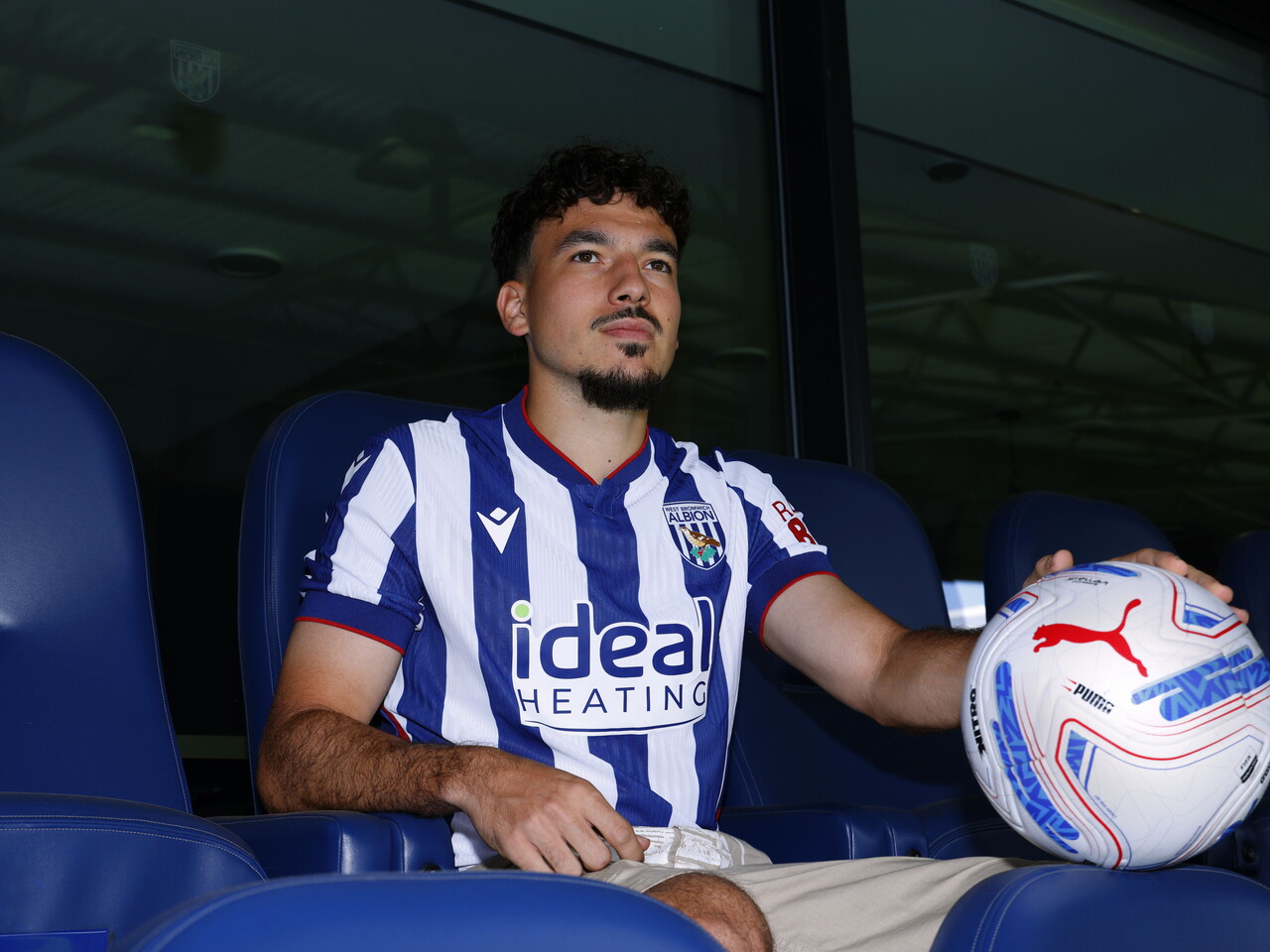 Nolan Galves sat in a chair in the home shirt holding a ball