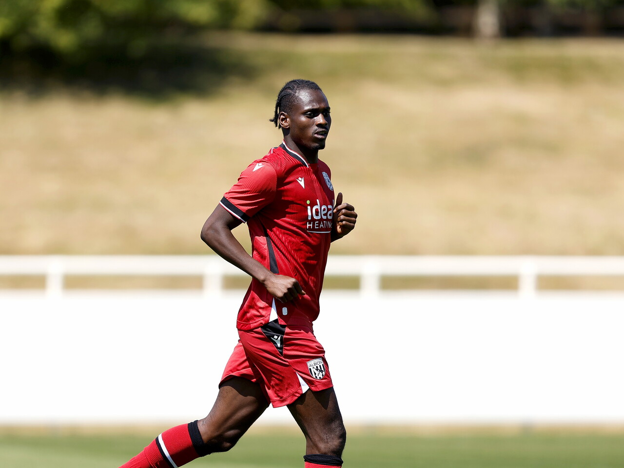 Albion in action against Sheffield Wednesday in pre-season, in red away colours.