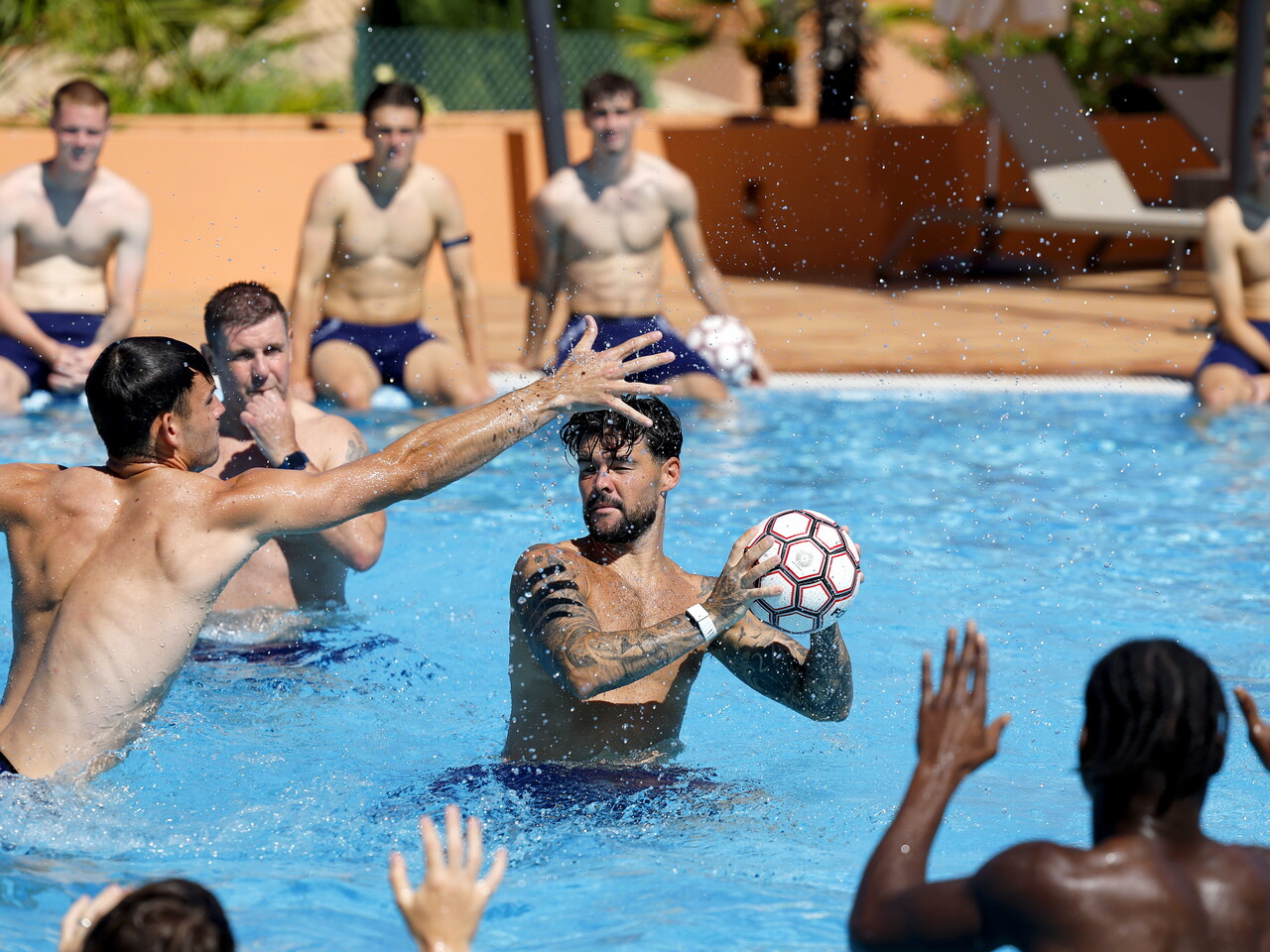 Several WBA players playing with a ball in a swimming pool