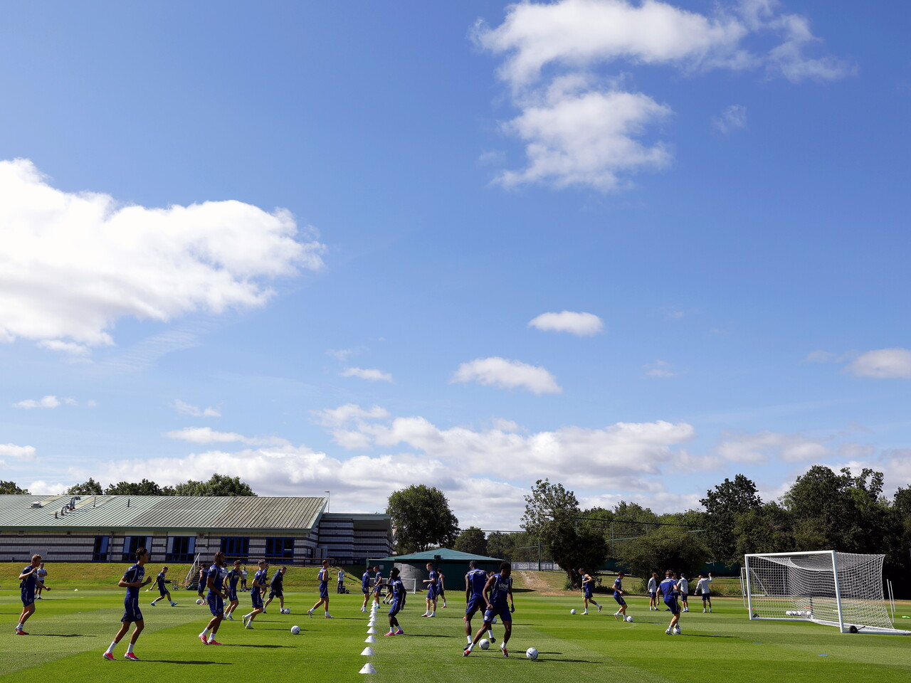 A general view of the training pitch with blue skies above and a session going on 