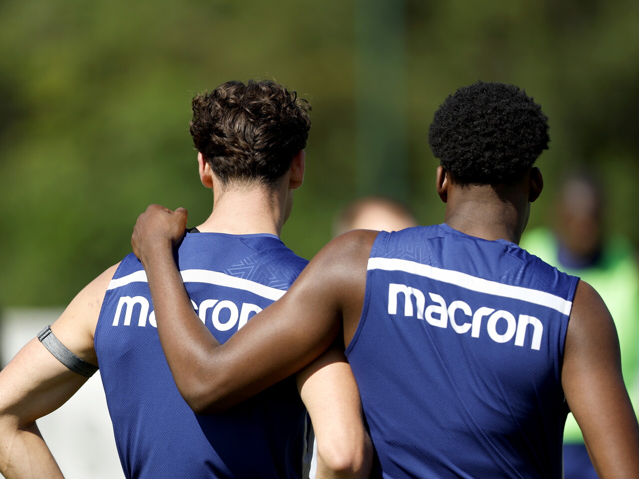 Souleyman Mandey with his arm around Barney Stewart during a training session with the pair facing away from camera