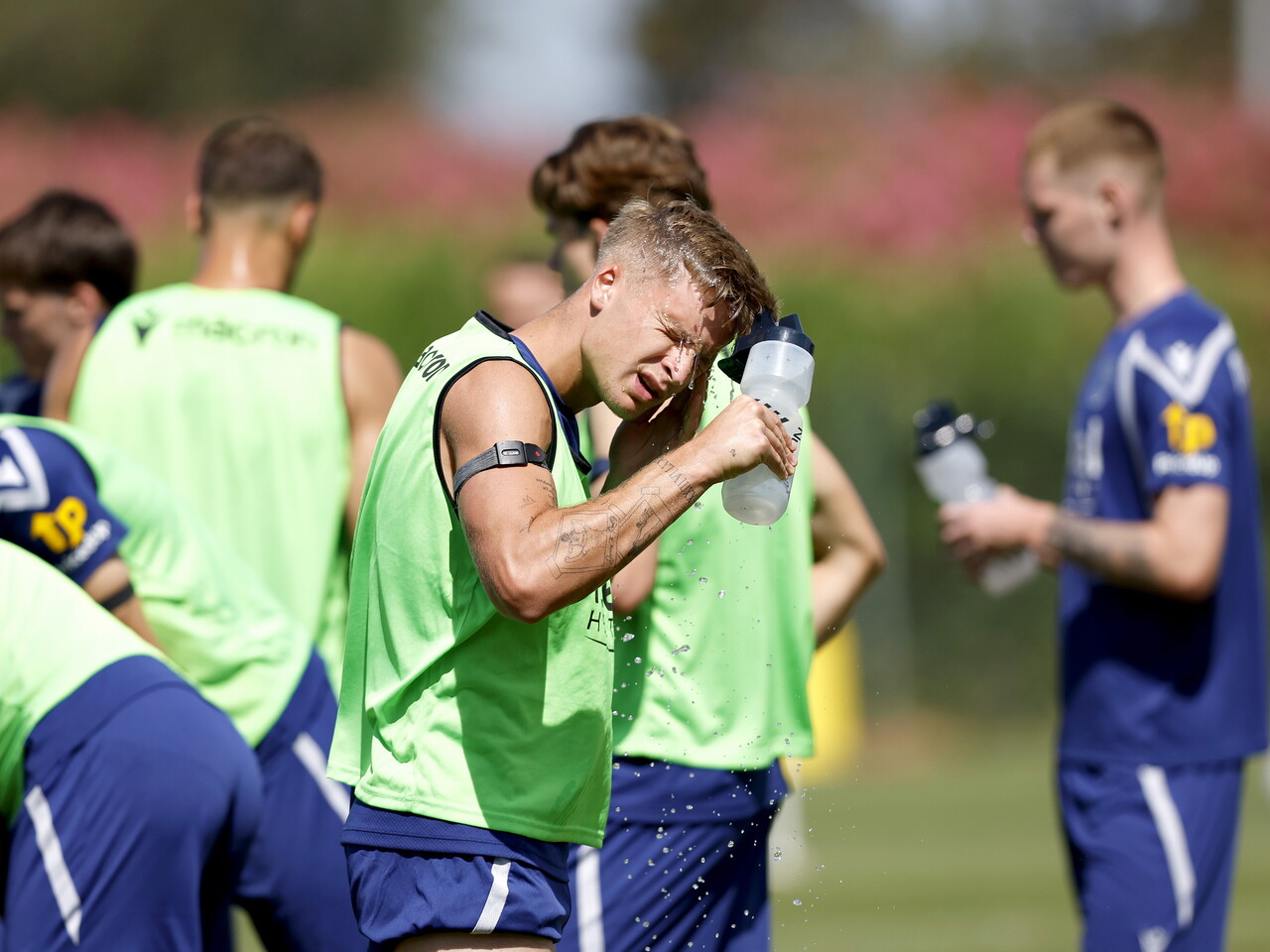 JJ Morgan squirting water on his face during a training session