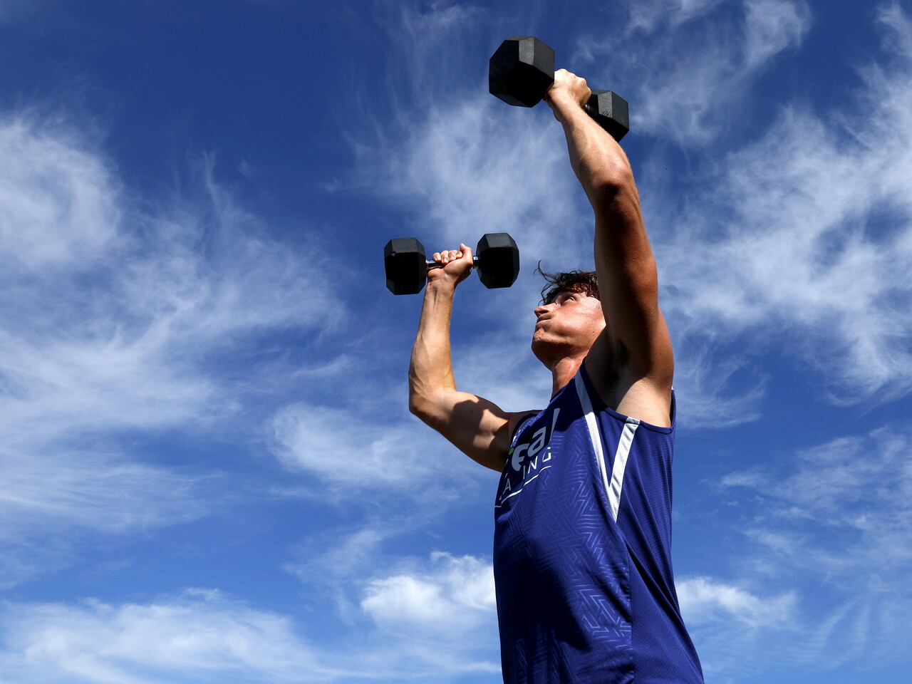 Barney Stewart lifting weights above his head 