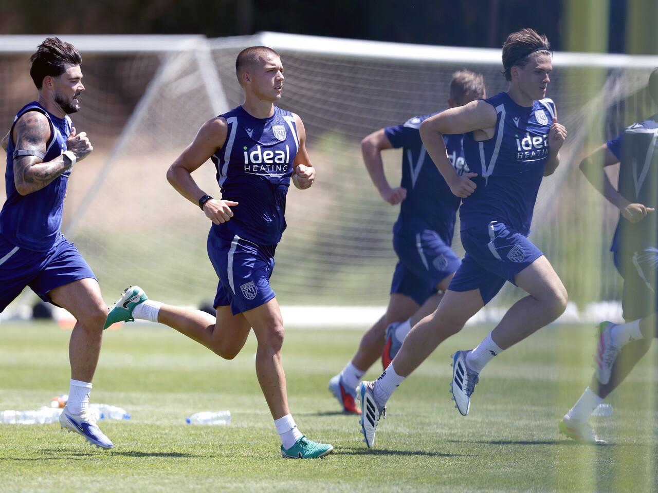 Several Albion players running forward during a training session