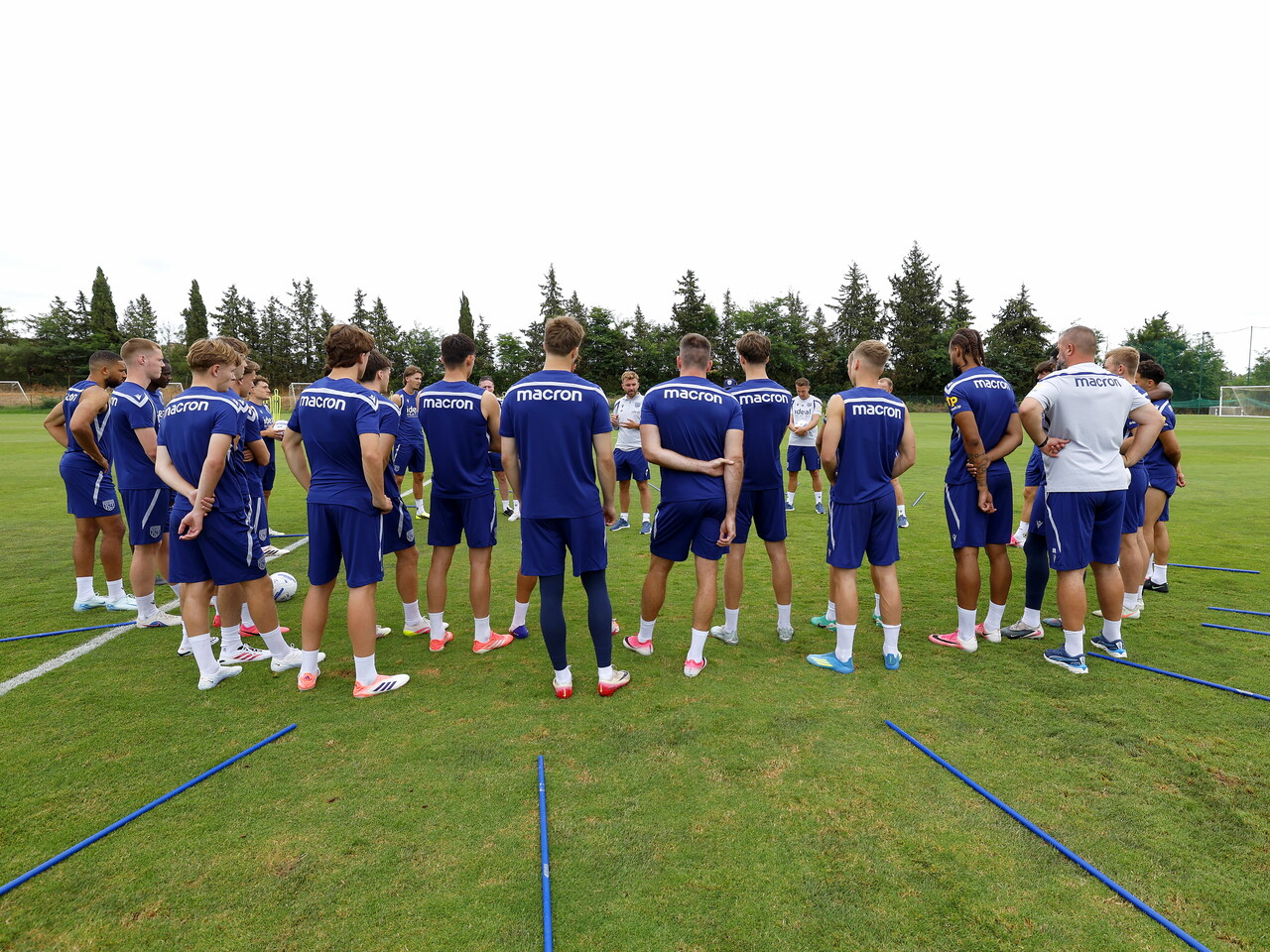 James Morrison chatting to players and staff on the training pitch in a group huddle