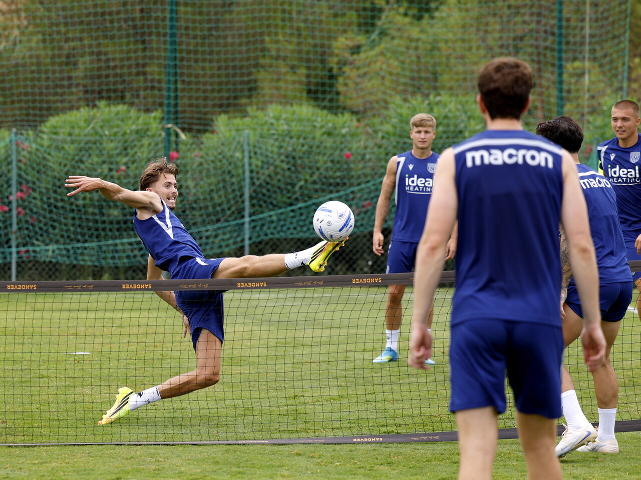 Isaac Price stretching to reach a ball during a football tennis session