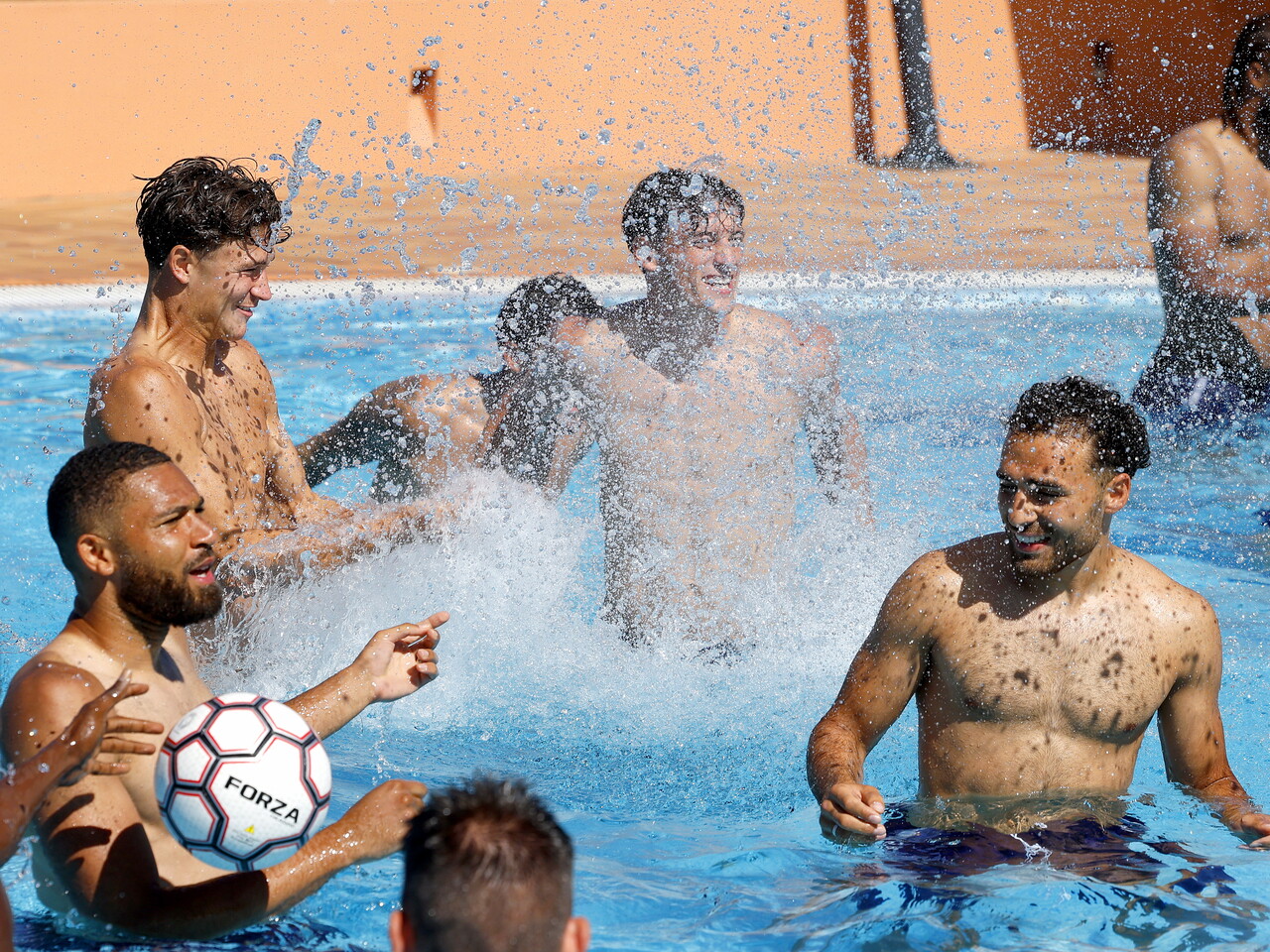 Several WBA players splashing in the pool during a game