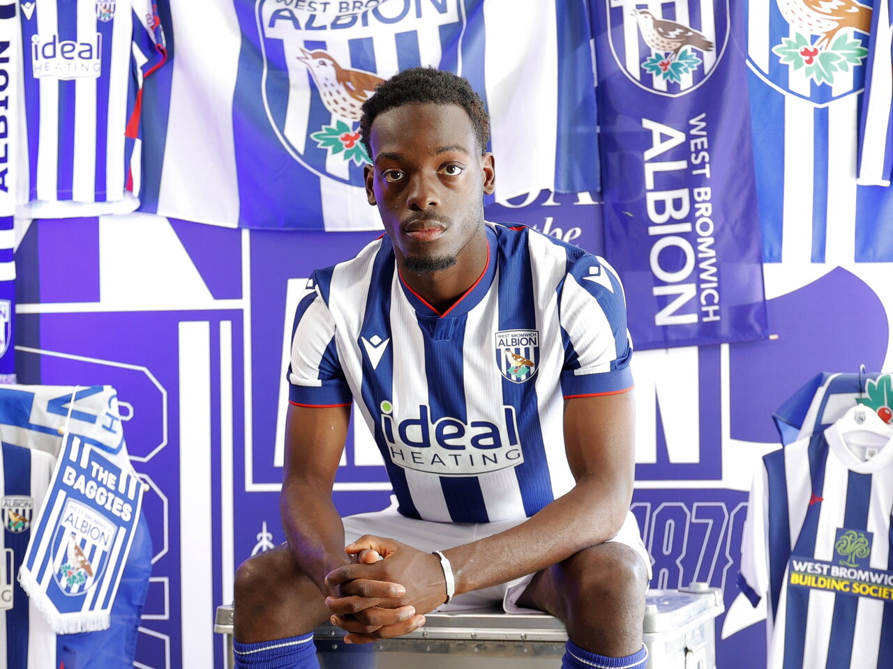 Rabby Nzingoula poses in front of a creative background in the home shirt