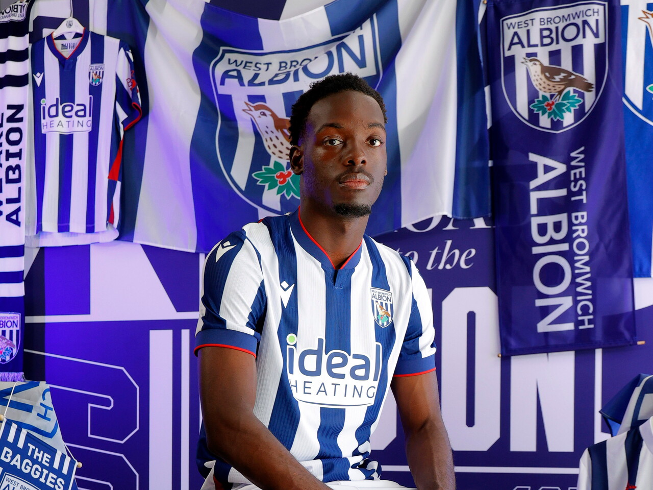 Rabby Nzingoula poses in front of a creative background in the home shirt