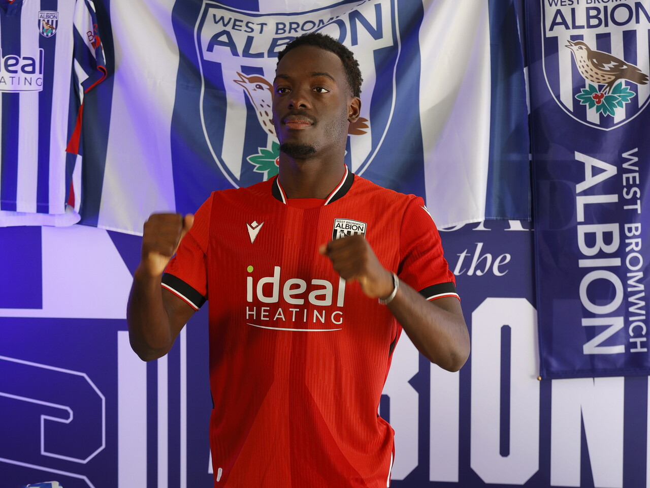 Rabby Nzingoula poses in front of a creative background in the away shirt