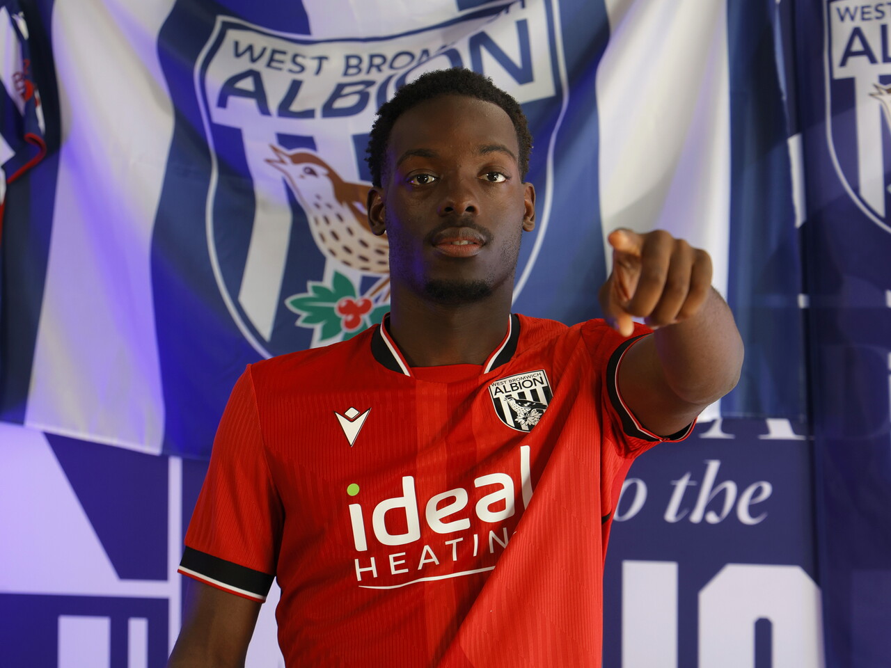 Rabby Nzingoula poses in front of a creative background in the away shirt