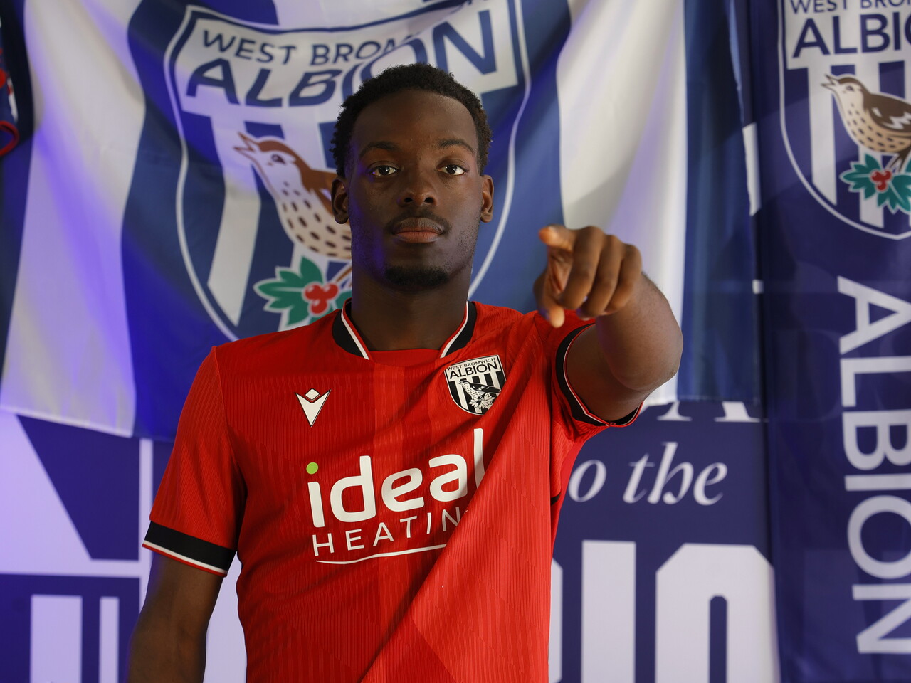 Rabby Nzingoula poses in front of a creative background in the away shirt