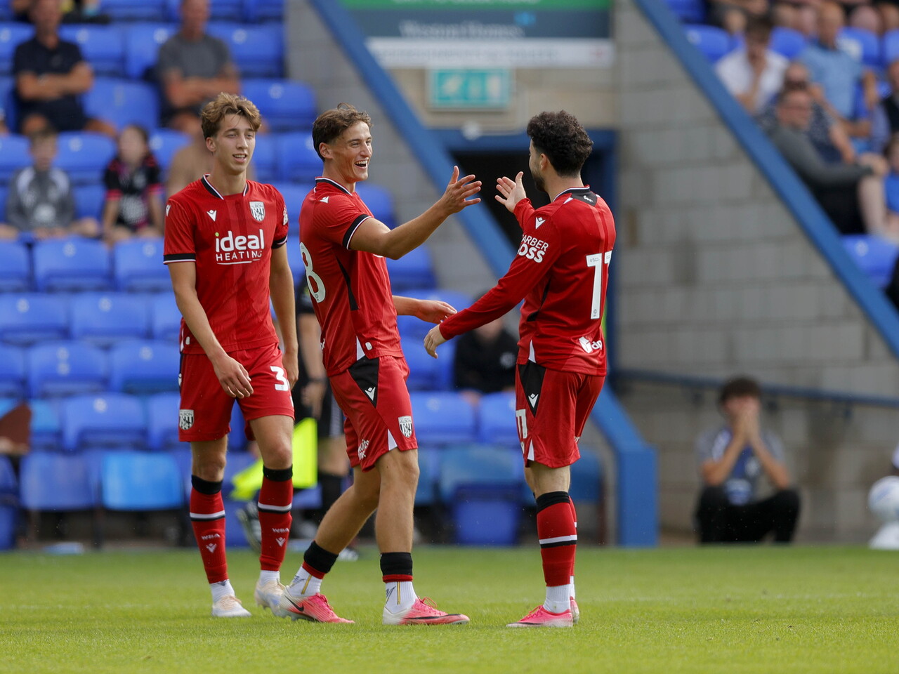 Barney Stewart celebrating with team-mates after scoring at Peterborough