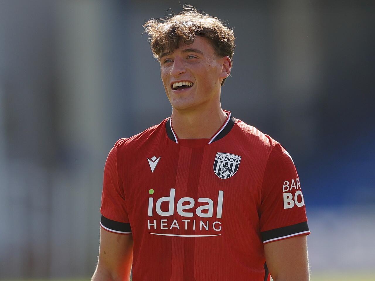 Barney Stewart smiling at WBA fans at Peterborough 