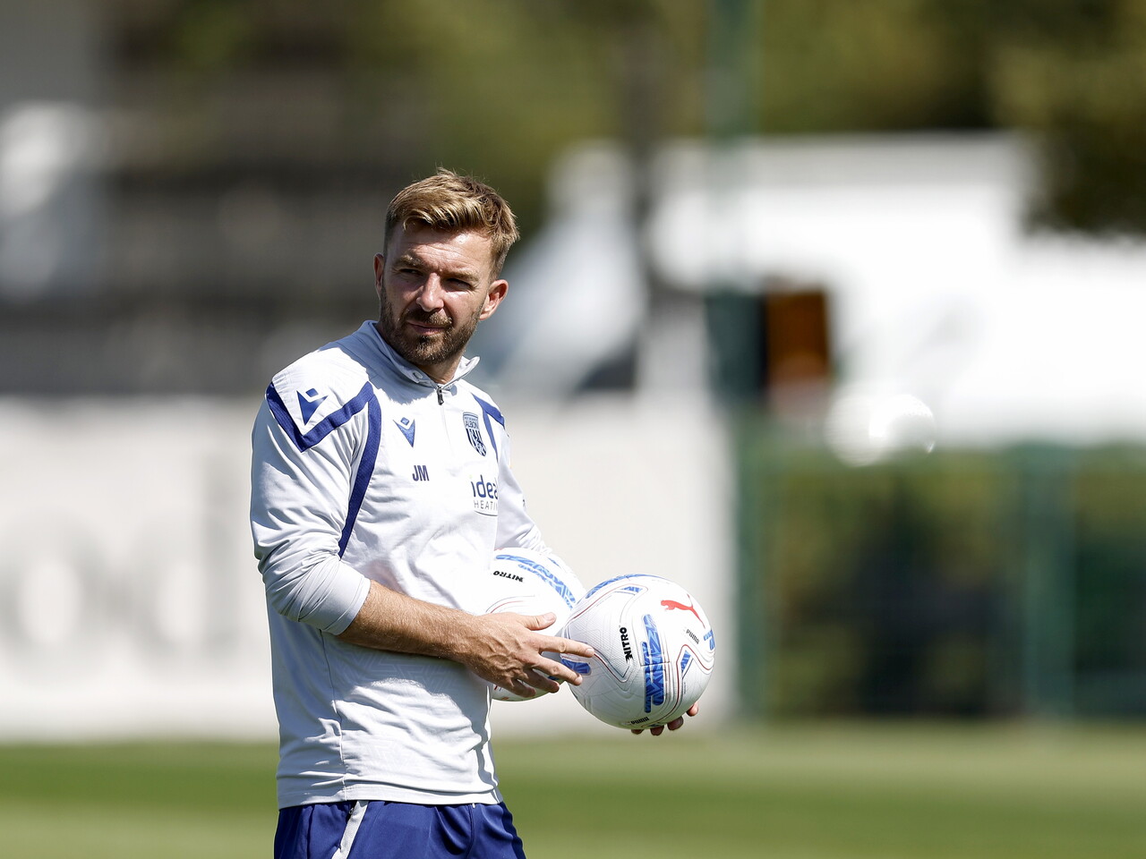 James Morrison holding two footballs during a training session