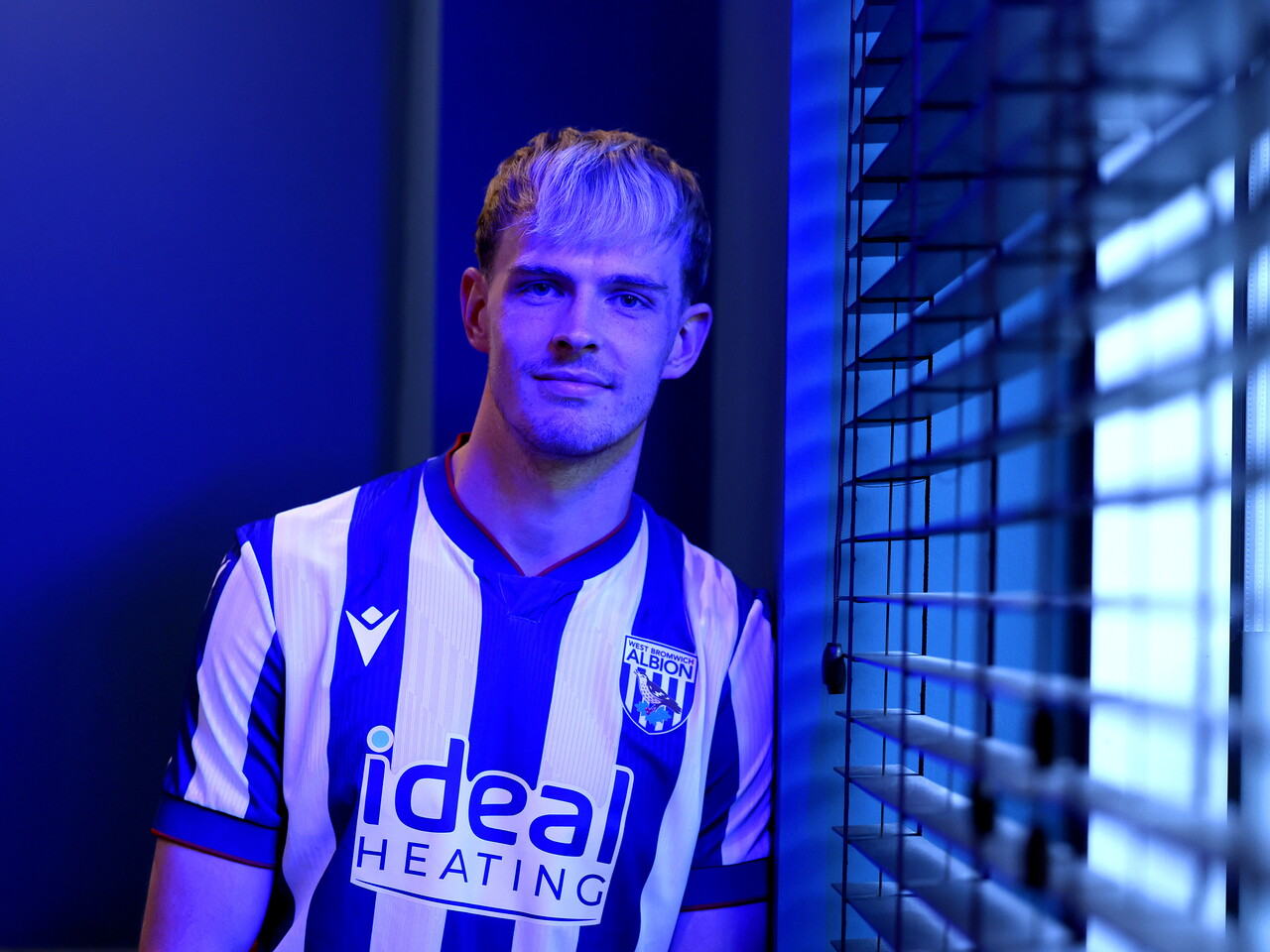 Toby Collyer poses in blue light