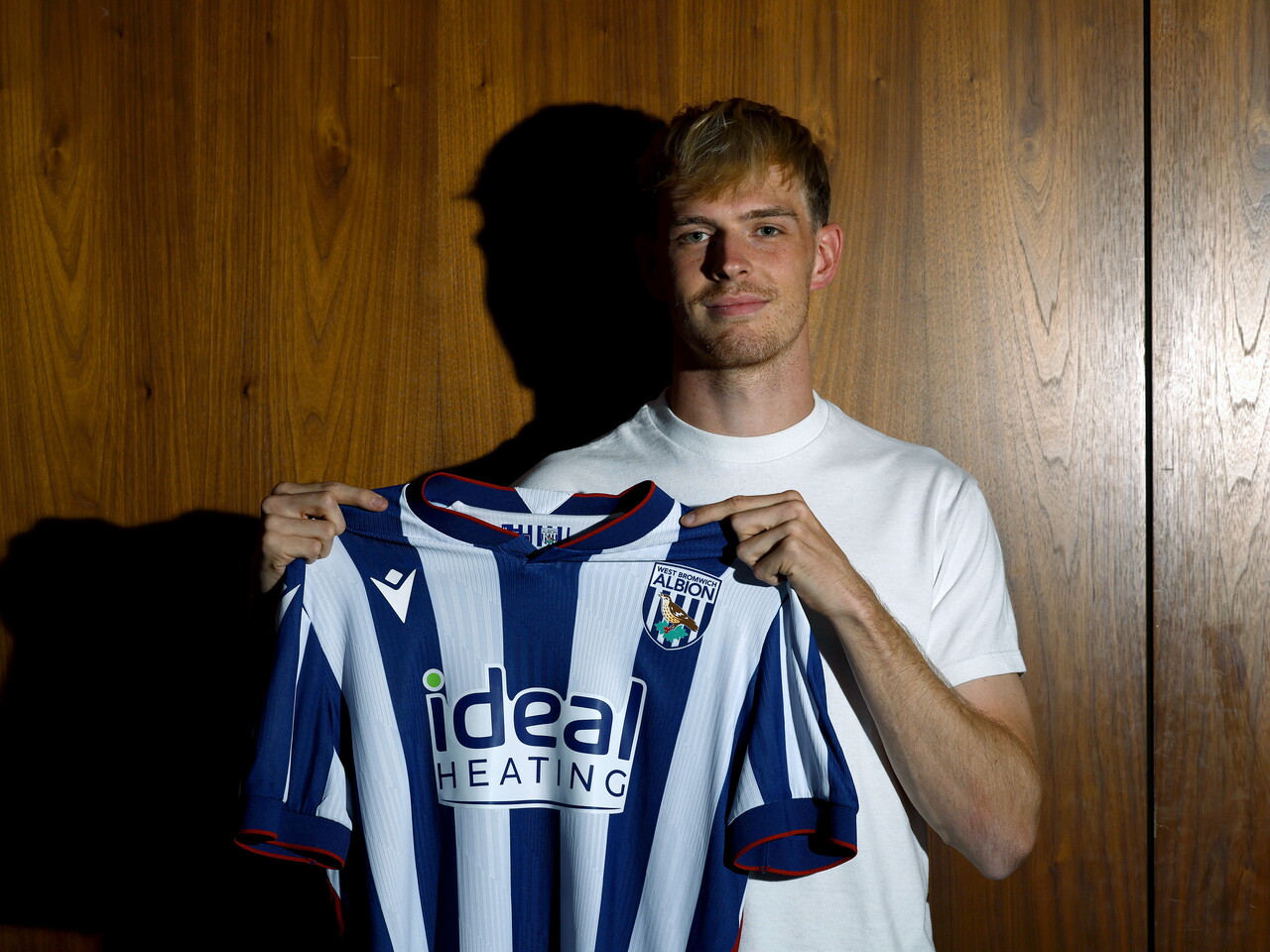 Toby Collyer holding the 26/27 home shirt