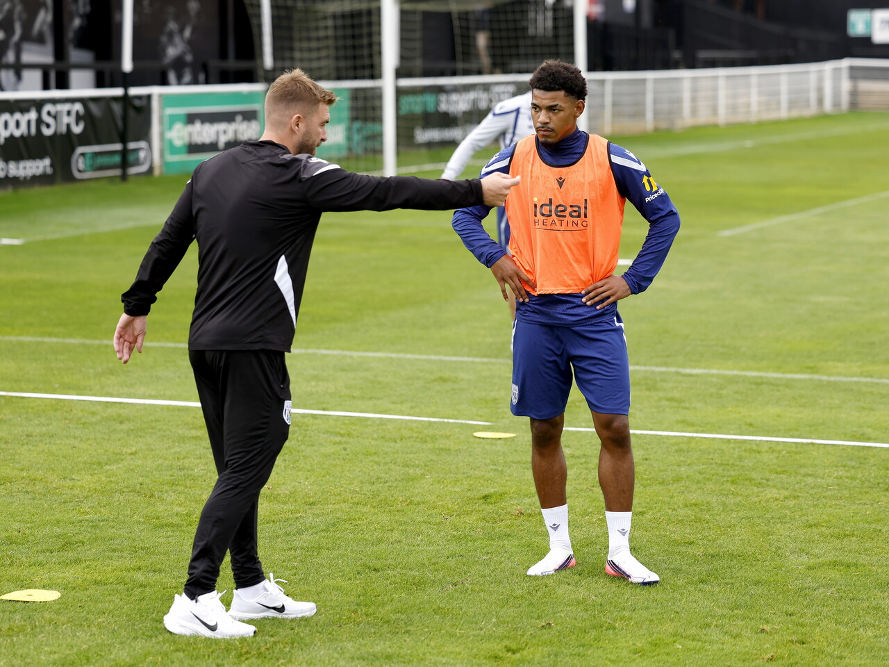 Kareem Tunde talking to James Morrison during a training session