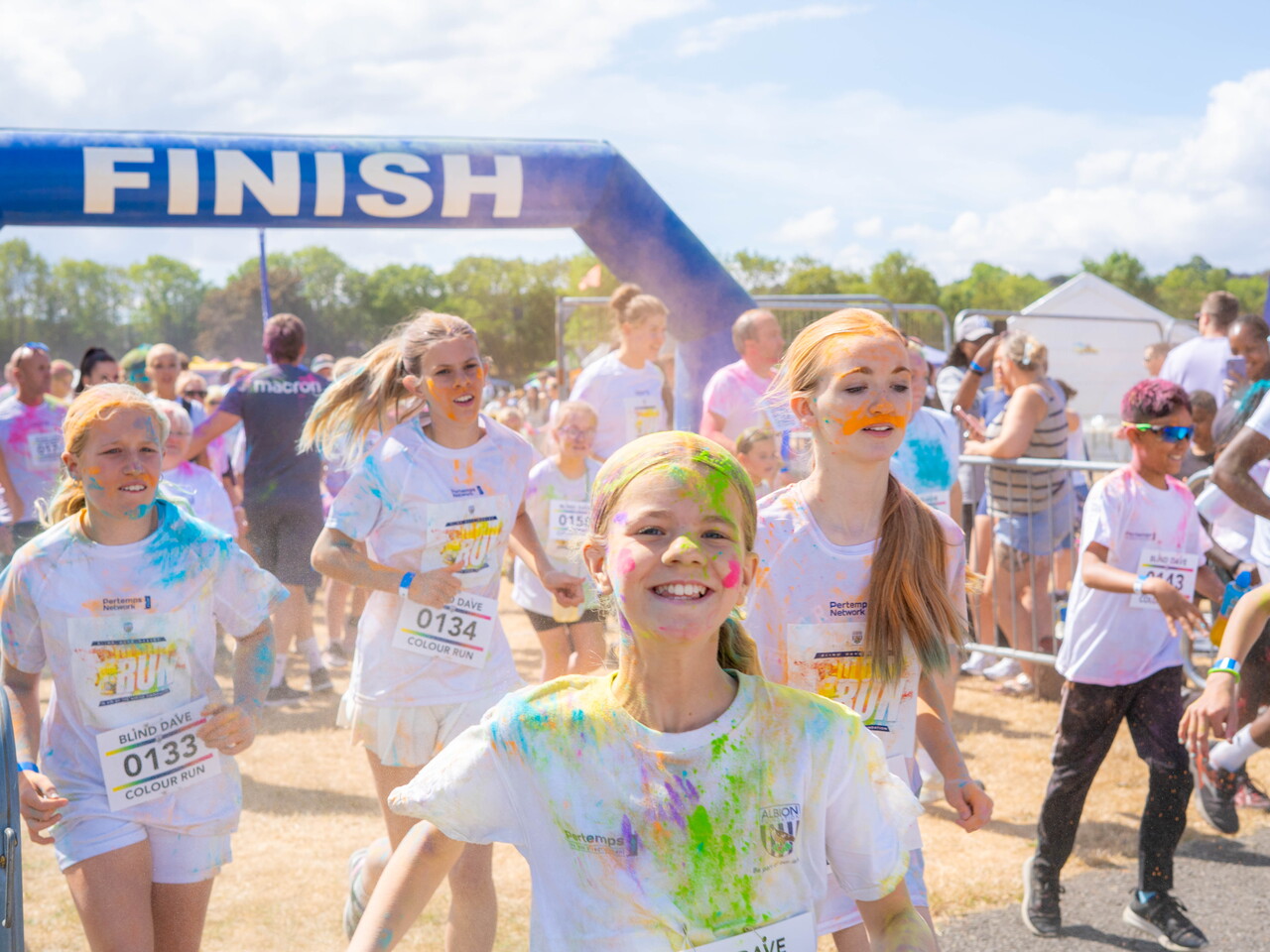 Participants covered in coloured powder run at the start line.