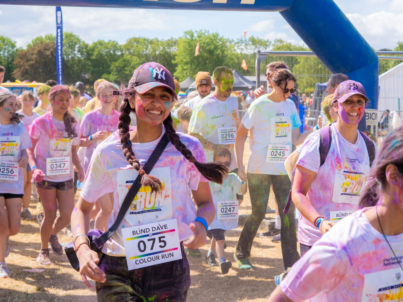 Participants smiling through the start line arch.