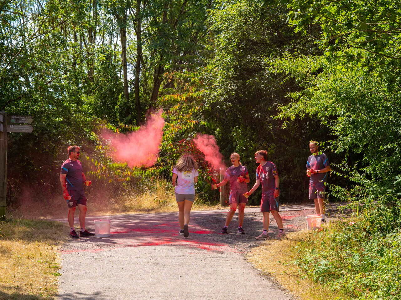 Participants move through a red powder station on the course.
