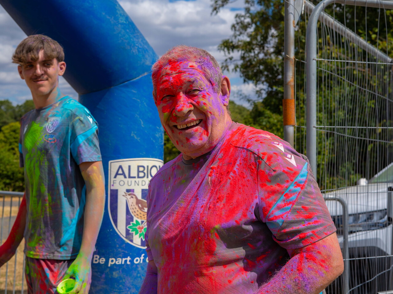 Foundation staff members covered in coloured powder posing for a portrait.