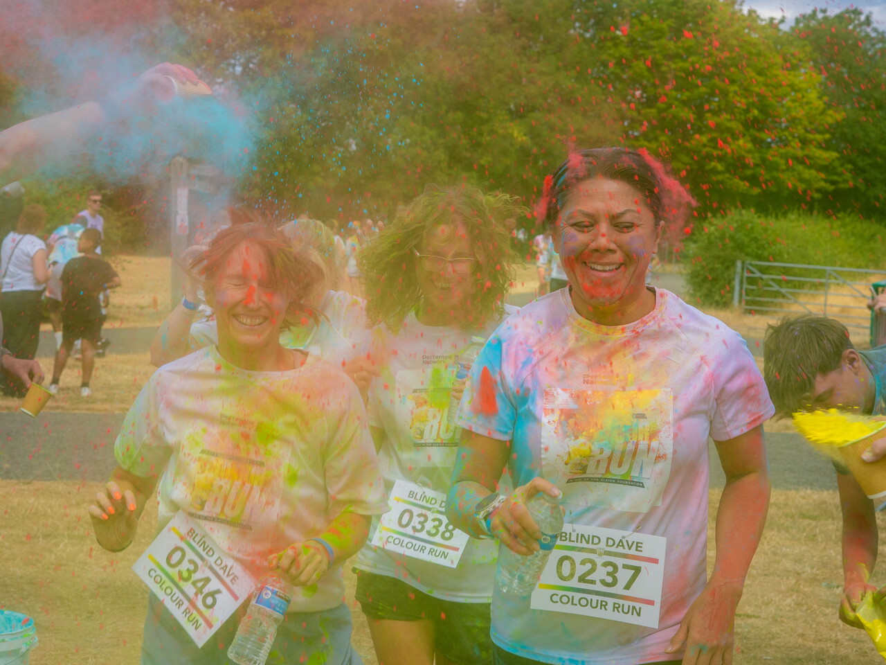 Participants running through the finish area covered in paint.