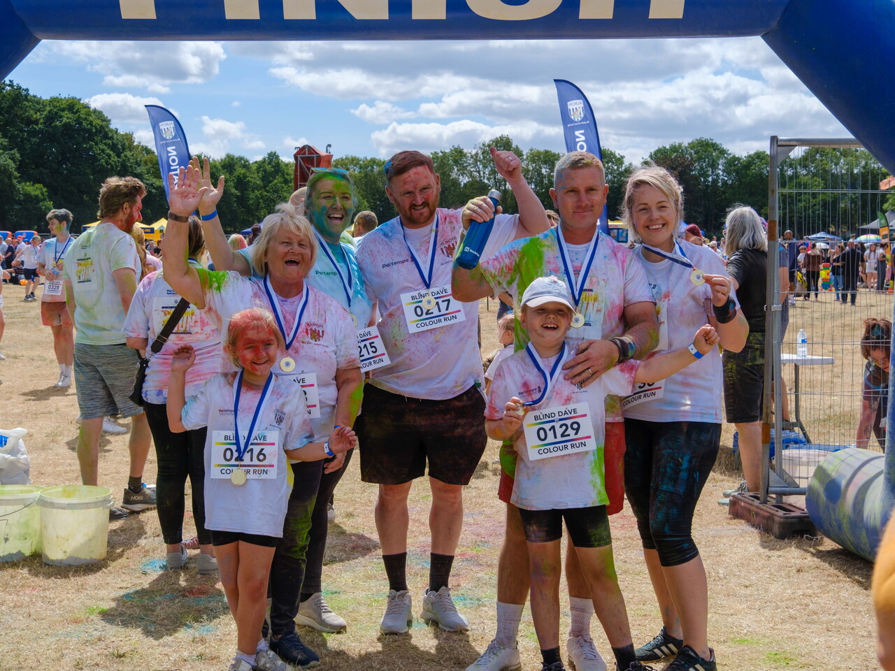Group of posing for a photo next to the FINISH arch.