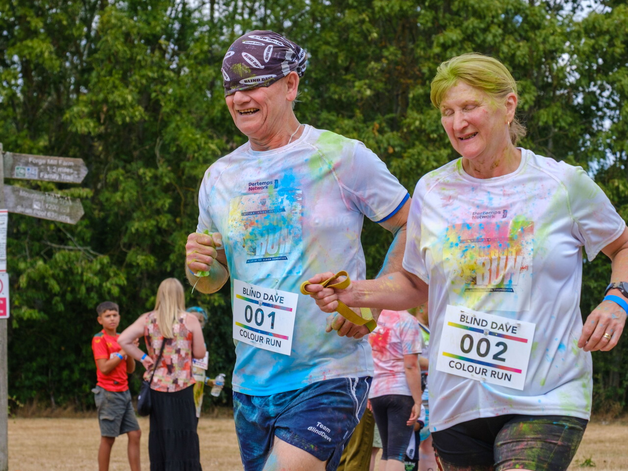 Blind Dave and guide running together towards the finish line.