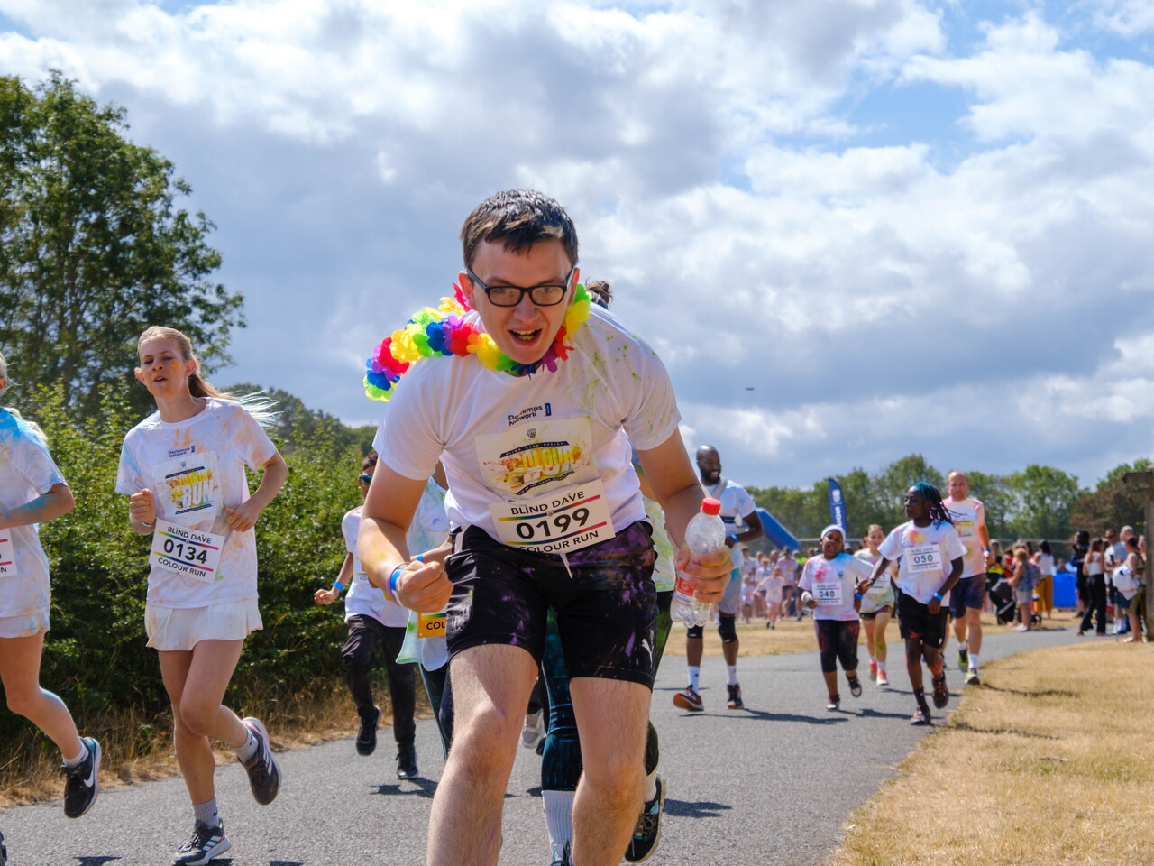 Participants cheering toward the camera during the color run event.