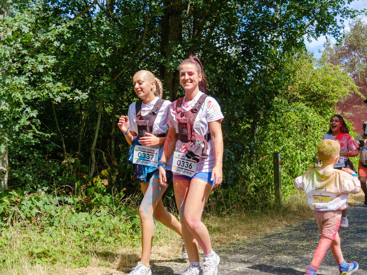 Two participants walk together along a wooded section of the course.