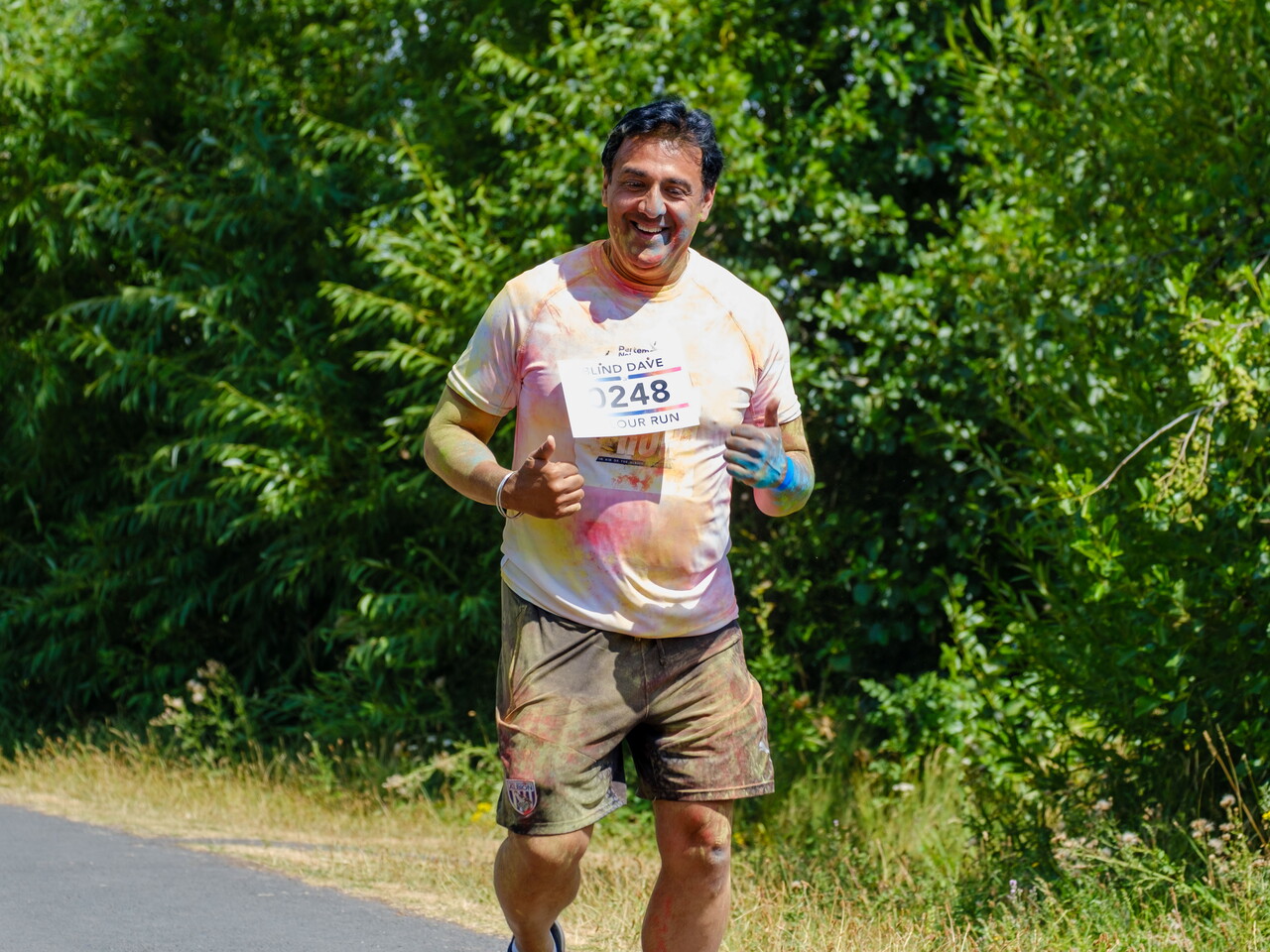 A participant runs alone along a tree-lined section of the route.