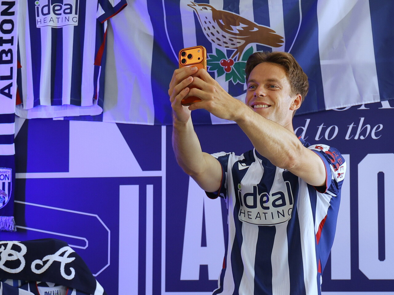 Felix Horn Myhre taking a selfie while in the home kit in front of WBA branding