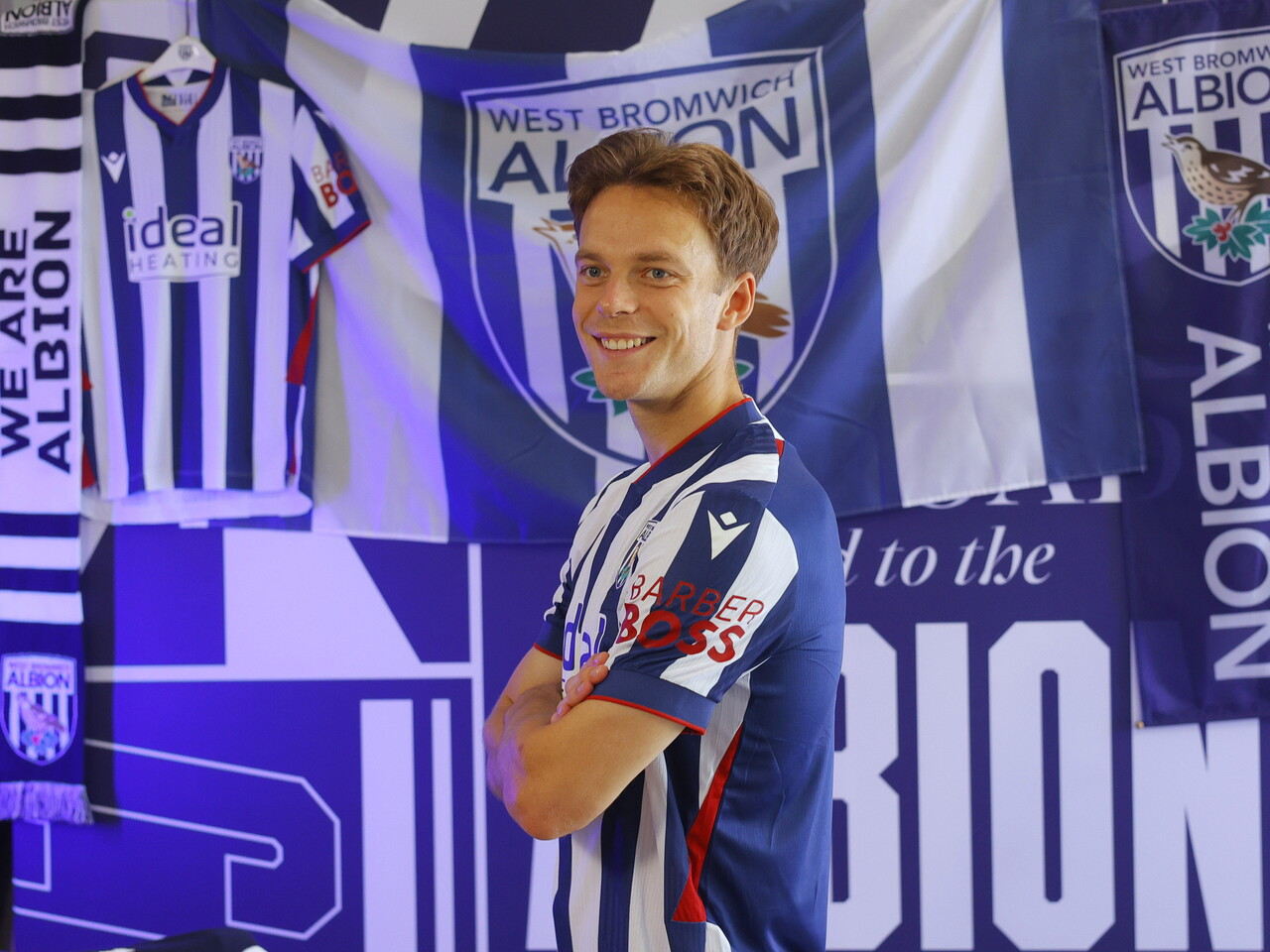 Felix Horn Myhre looking towards the camera while stood in the home kit in front of WBA branding