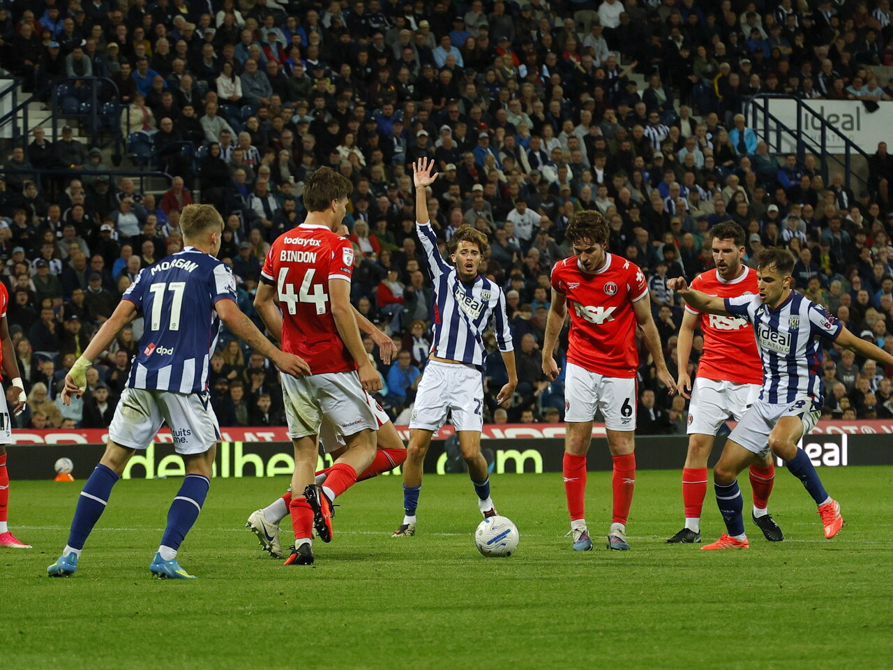 Several players next to the ball with Isaac Price holding his hand in the air