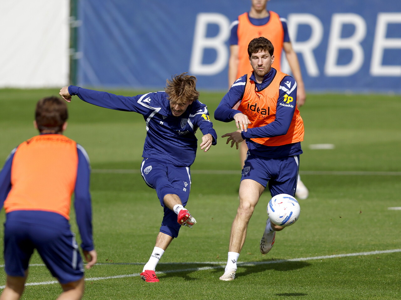 Isaac Price shooting during training, closely watched by Chris Mepham