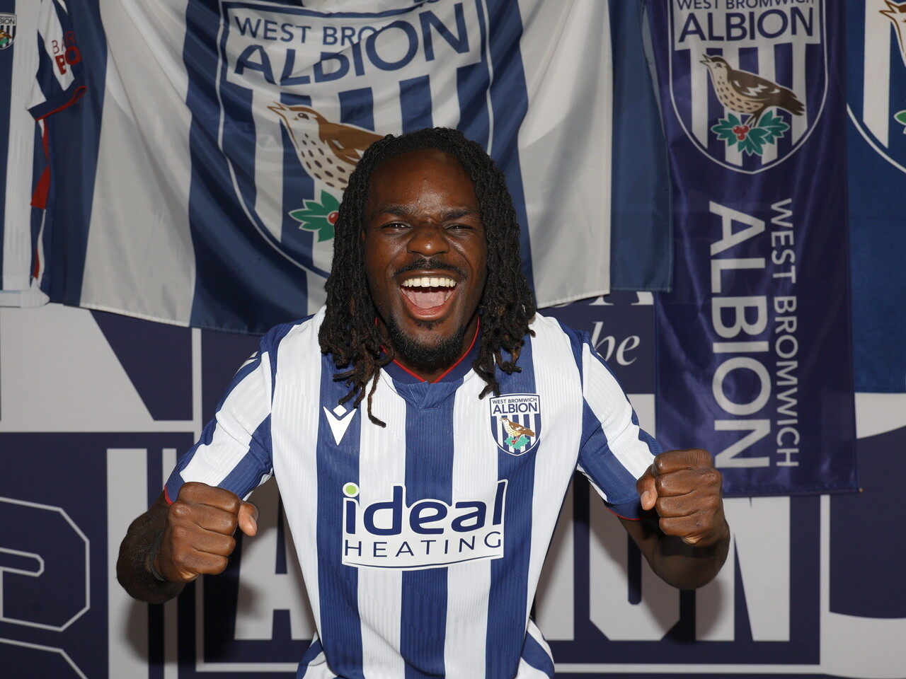 Brayann Pereira celebrating at the camera while stood in the home kit in front of WBA branding 