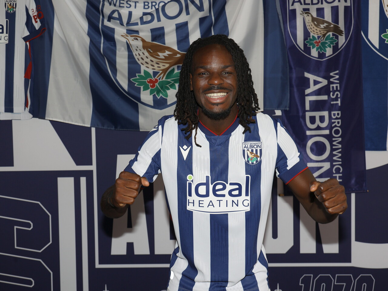 Brayann Pereira celebrating at the camera while stood in the home kit in front of WBA branding 