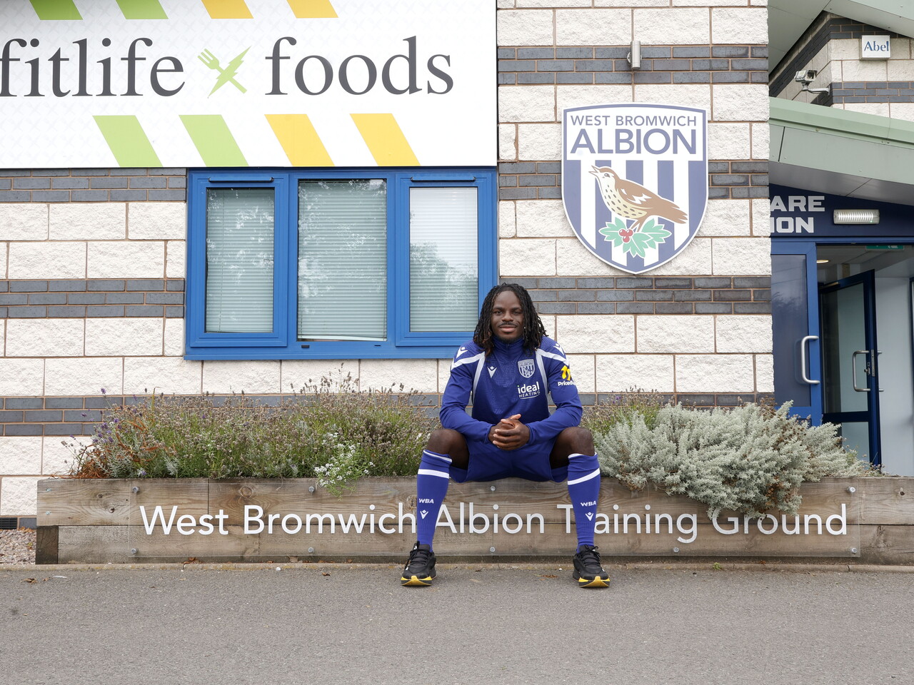 Brayann Pereira smiling at the camera while sat outside the training ground 
