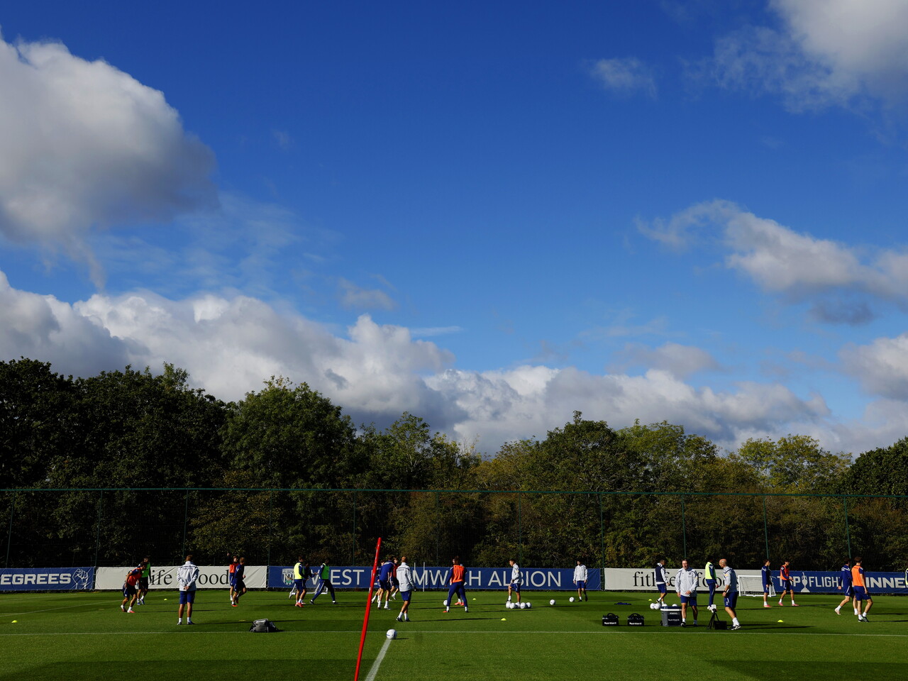 A general view of a training pitch with a session taking place and several players on it with blue skies above