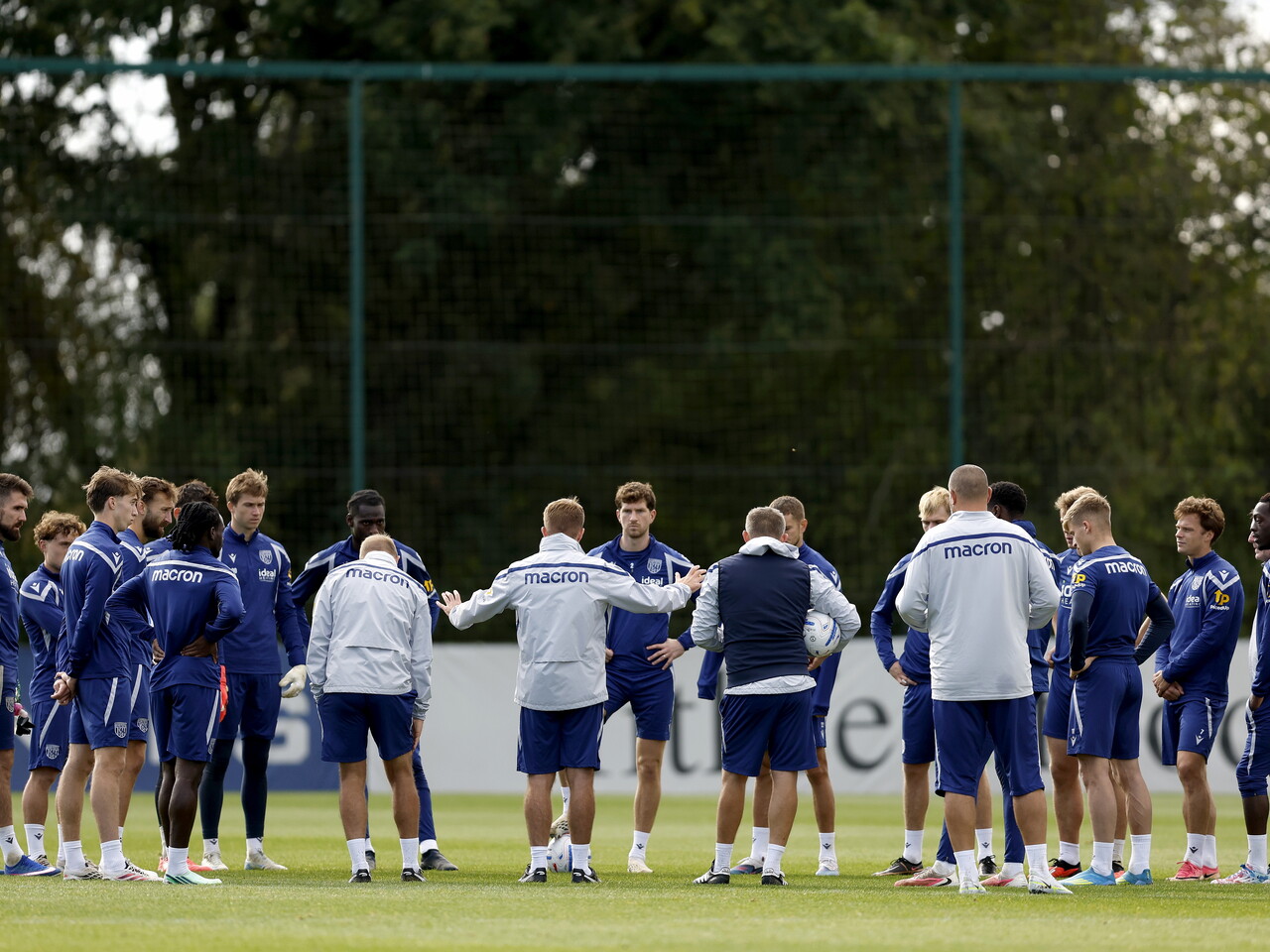 James Morrison talking to players and staff in a circle on the training pitch