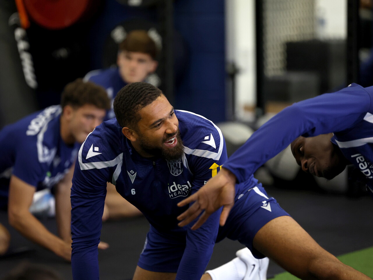 George Campbell chatting and stretching in the gym